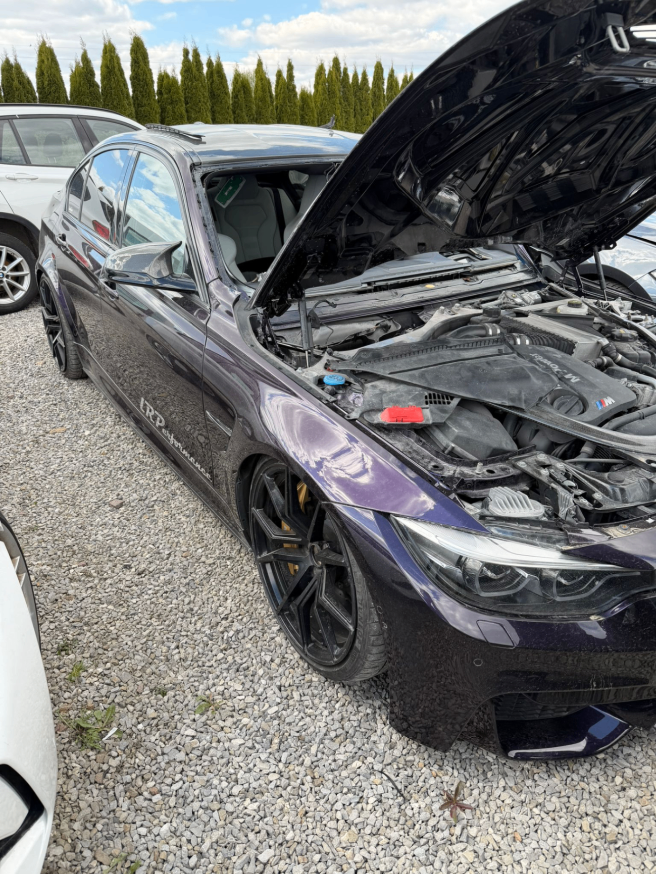 BMW z otwartą maską przygotowane do serwisu szyby w terenie
